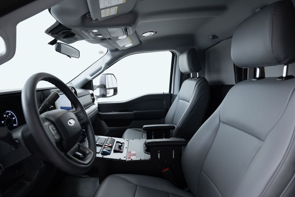Demers ambulance cab interior with ergonomic driver and passenger seats, integrated center console controls, and a clear, driver-focused dashboard layout