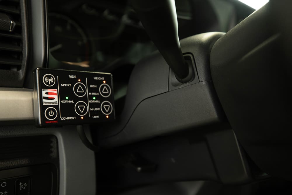 Close-up of a Demers ambulance cab showing a dashboard-mounted ride and suspension height control panel with buttons for sport, normal, comfort, and adjustable vehicle height settings