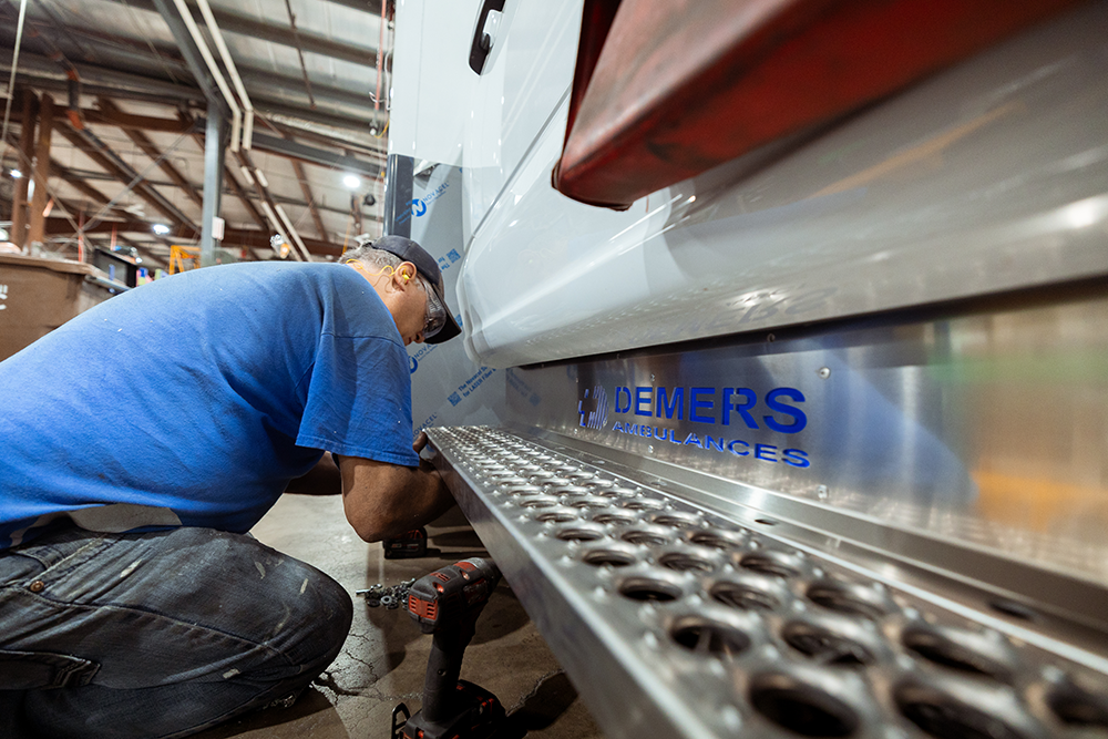 Demers employee using power tools to work on an ambulance inside a manufacturing facility