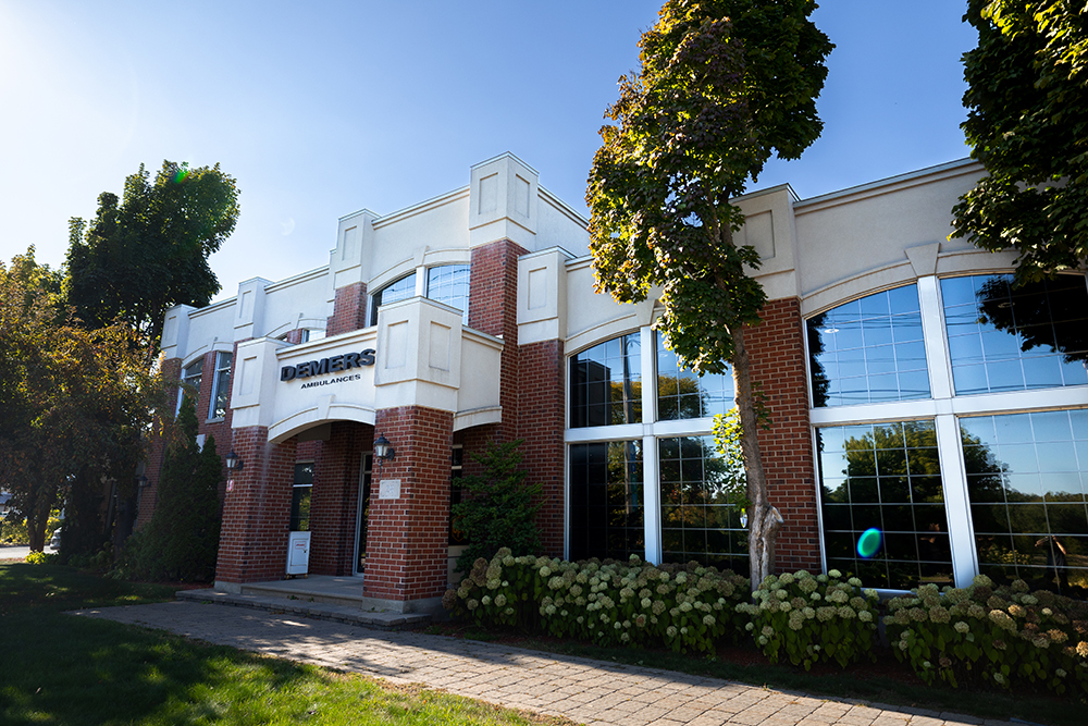Brick office building with large windows and Demers Ambulances signage
