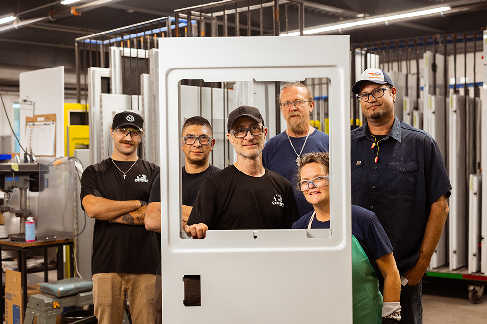Group of employees standing together inside a Demers manufacturing facility